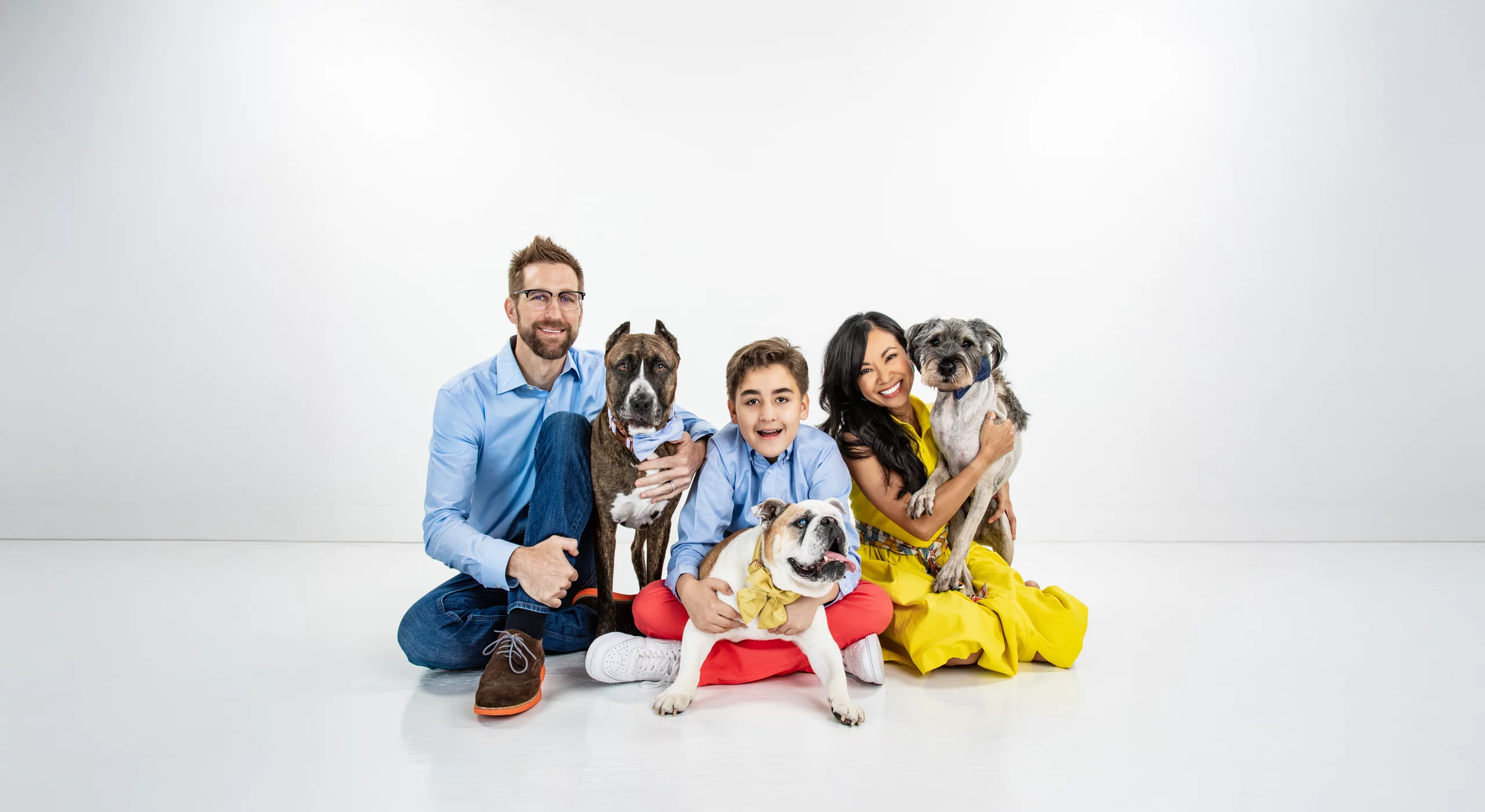 family photo including a man, woman, son, and three dogs